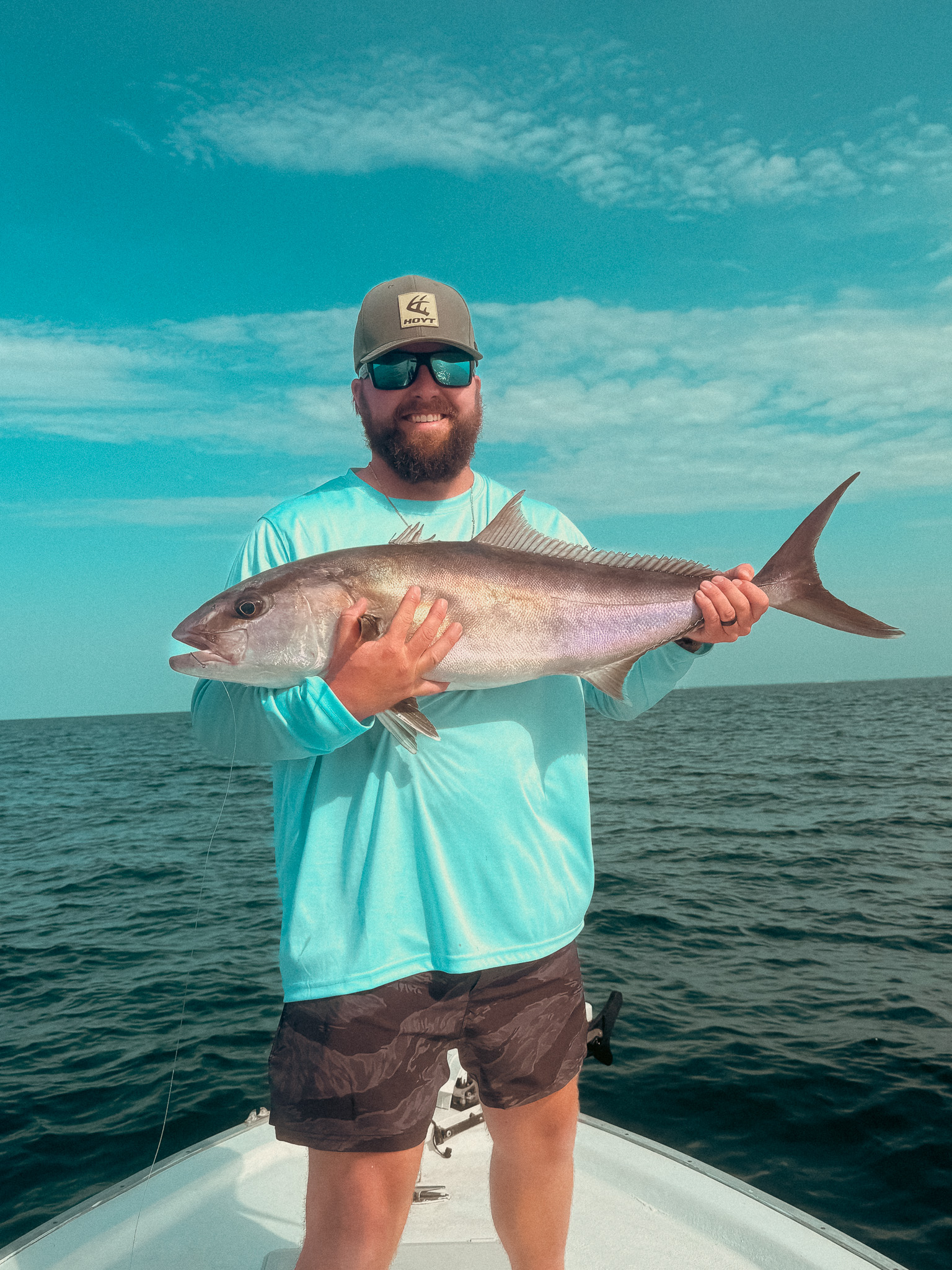man holding amberjack on a near-shore gulf fishing trip